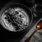 A bowl of yogurt with granola and berries.