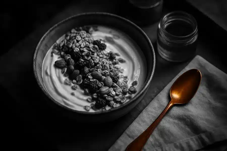 A bowl of yogurt with granola and berries.