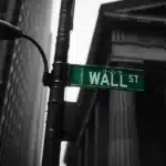 Wall Street sign with a classical building in the background.