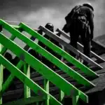 Construction workers on a residential roof, building frame in foreground.