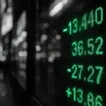 Electronic stock ticker displaying market data in a city environment.