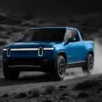 Rivian SUV driving in a desert landscape.