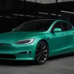 A Tesla car parked outside a glass building.