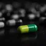Capsules scattered on a reflective surface
