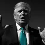 A prominent public figure making a forceful gesture.