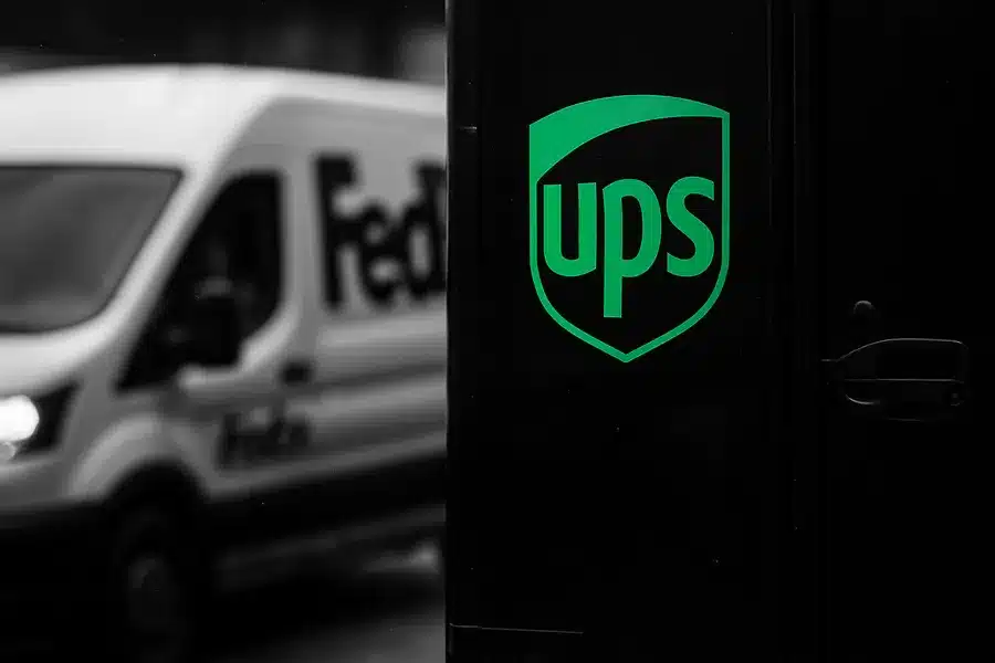 FedEx and UPS delivery vans in an urban setting.