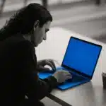 Person working on a laptop at a desk.