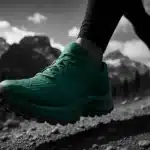 A runner's shoe caught mid-stride against a scenic mountain backdrop.