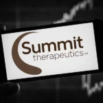 Smartphone displaying the Summit Therapeutics logo against a stock market background.