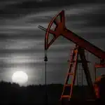Silhouette of an oil pump jack against a sunset.