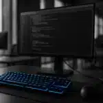 An array of computer monitors displaying code in a modern office setting.
