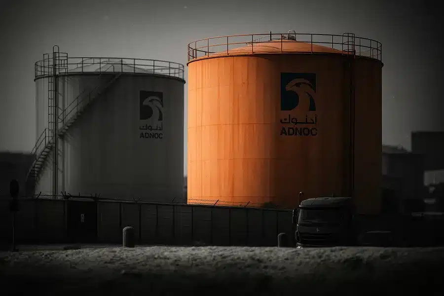 Oil storage tanks with ADNOC logos.