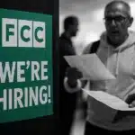 A 'We're Hiring' sign at a job fair, symbolizing job growth.