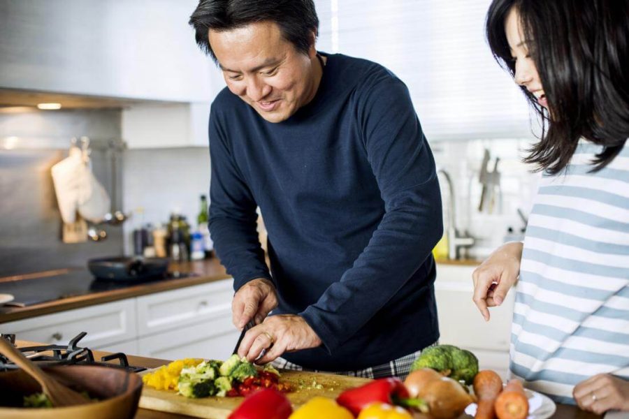 couple-chopping-vegetables-and-cooking-in-kitchen-for-paleo-diet